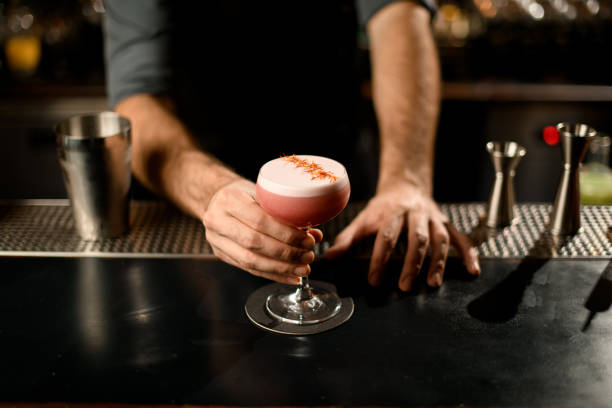 istock Bartender holding decorated alcohol cocktail in small glass 1195836828