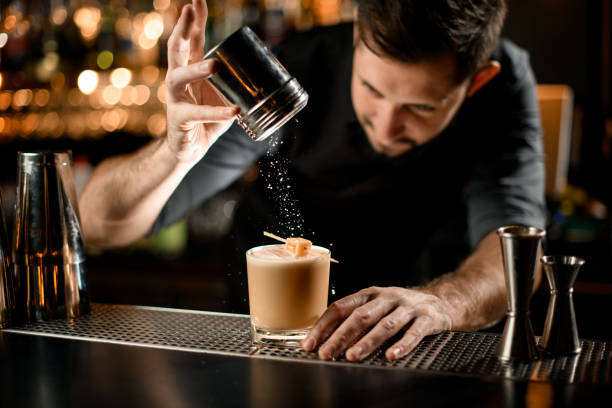 istock Bartender sprinkles an alcohol cocktail with sour mix and candy 1195837458