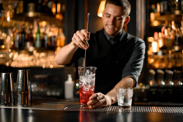 bartender stirring alcohol drink with a bar spoon - men elegance cocktail cool imagens e fotografias de stock