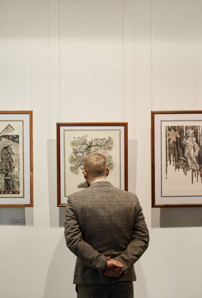istock Man looking at paintings at gallery 1195845051