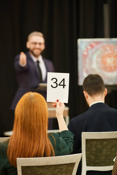 istock Woman with sign at auction 1195845064