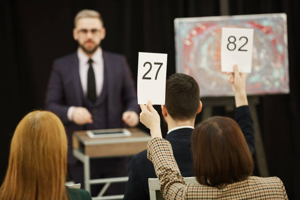 istock People with signs at auction 1195845265