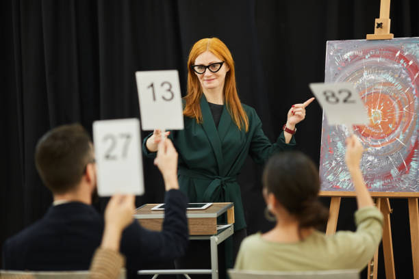istock Woman presenting the art at auction 1195845500