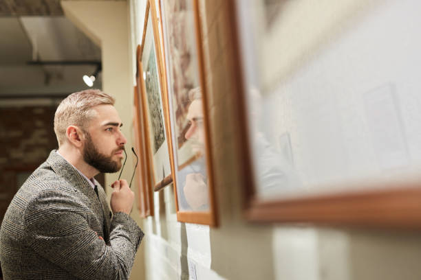 istock Man examining the paintings 1195845557
