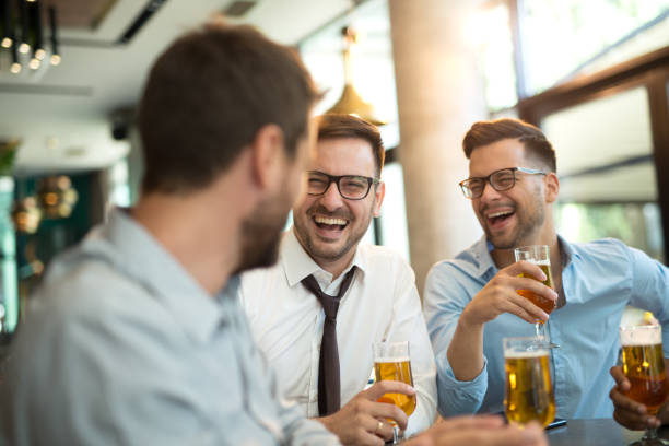 istock Funny conversation four businessmen while sit pub and drinking beer after work 1195851056