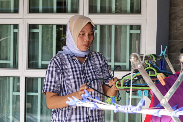 An Indonesian ethnicity woman is doing laundry as part of house errands in Malaysia.