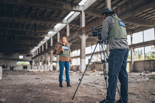 istock Man and woman journalists reporting from the war zone 1195866560