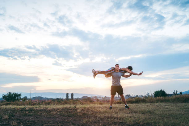 istock Man squatting with woman on shoulders 1195871747