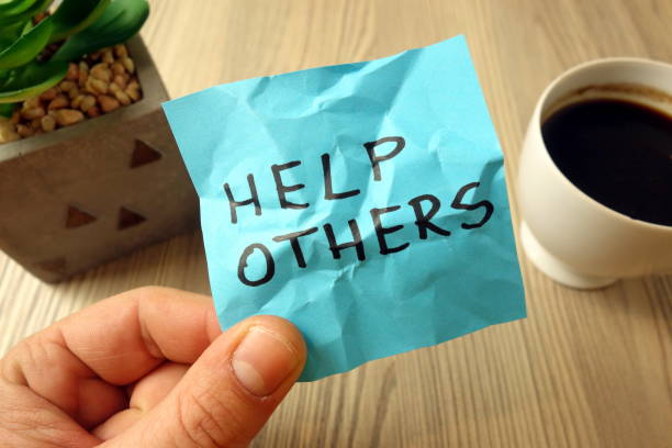 istock Help others - motivational reminder handwritten on sticky note 1195872459