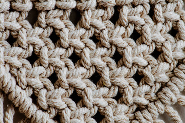 istock Texture of open-weaved macrame tapestry up close. Knots and ropes in a pattern. 1195874368