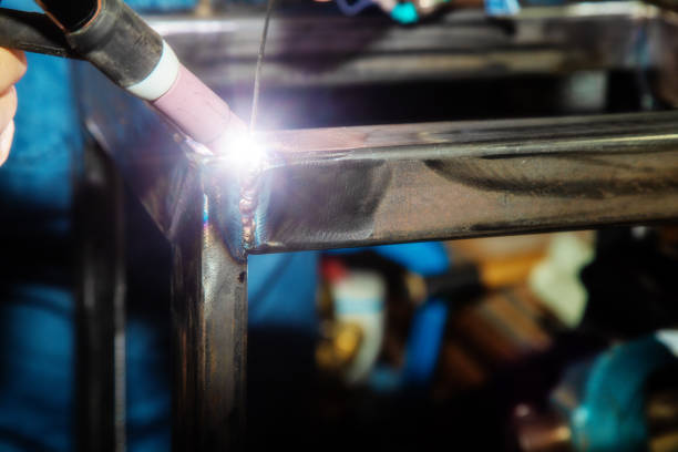 Female TIG welder welding steel