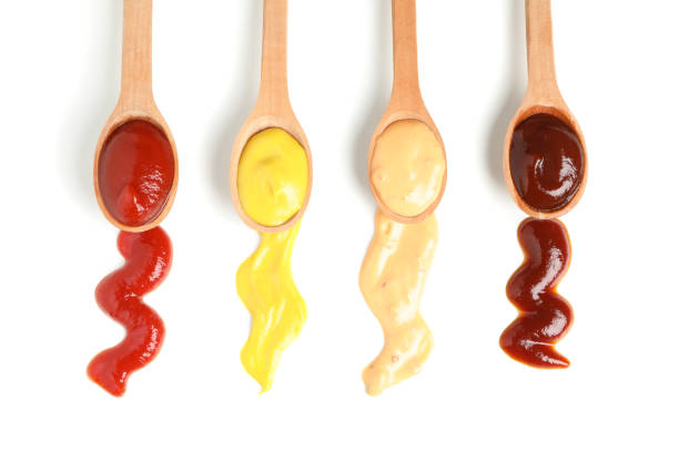istock Wooden spoons with sauces isolated on white background 1195877806