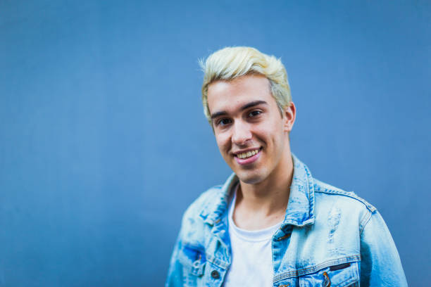 Portrait of a Hispanic Latin gay young man Portrait of a Hispanic Latin gay young man. He is standing against a blue wall looking at the camera. Palermo Soho, Buenos Aires, Argentina gay man photos stock pictures, royalty-free photos & images