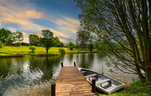wooden jetty and a boat on lakeside twilight
