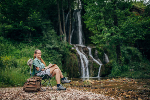 istock Lady biologist contemplating by the waterfall 1195888720