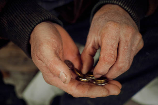 istock Old hands close up consider coins. Concept of poverty. 1195889466