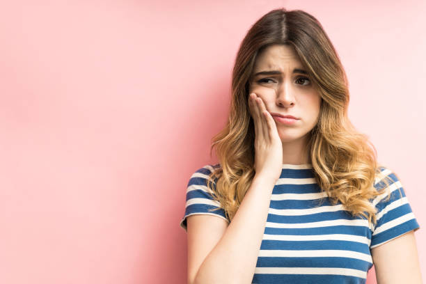 female feeling painful toothache against plain background - t shirt shirt pink blank imagens e fotografias de stock