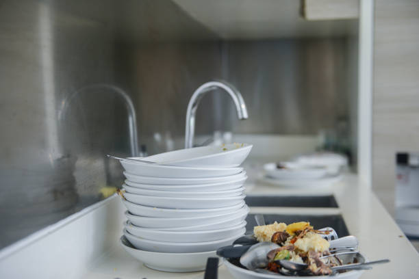istock Dirty dishes stacked in kitchen sink 1195893453