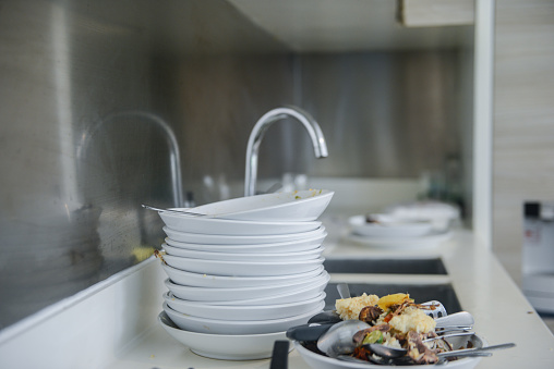 Dirty dishes stacked in kitchen sink.
