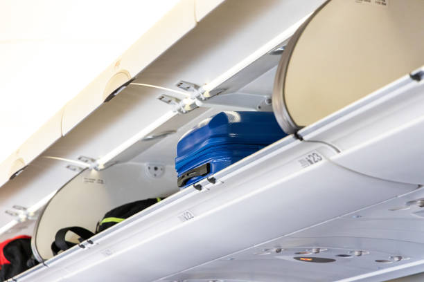 istock Aeroplane overhead luggage compartment with bags 1195895532