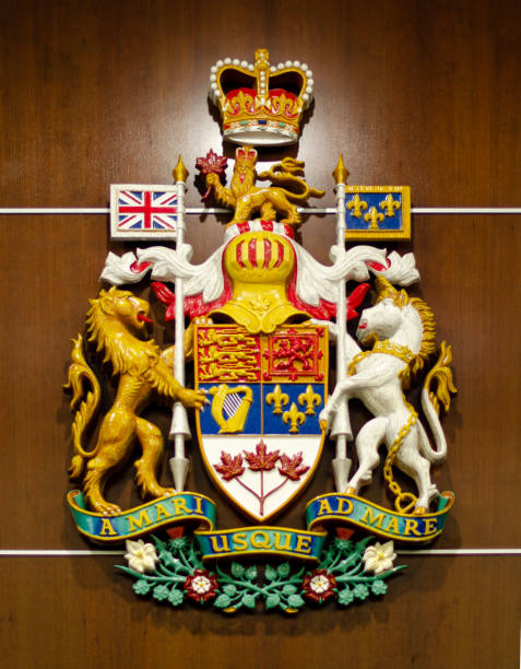 Federal coat of arms for Canada hanging in Calgary Court Centre in Calgary, Alberta. Painted design hung on a wood panel wall in a courtroom.