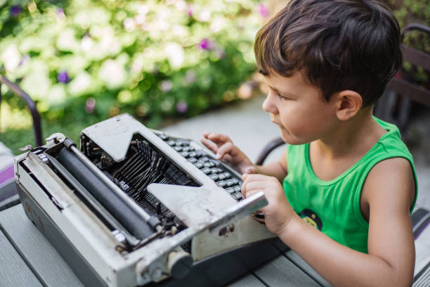 chłopiec ze starą maszyną do pisania - machine typewriter human hand typing zdjęcia i obrazy z banku zdjęć
