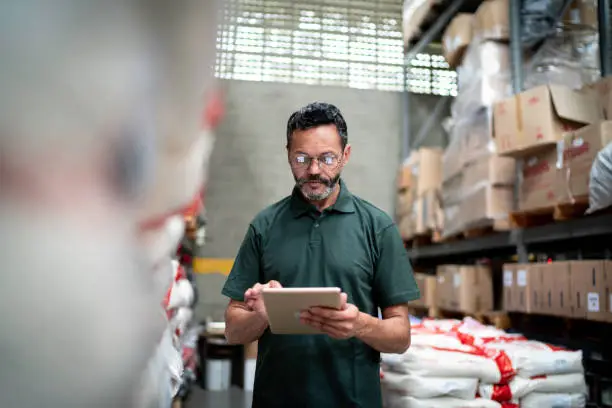 Photo of Manager using his tablet working in warehouse / industry