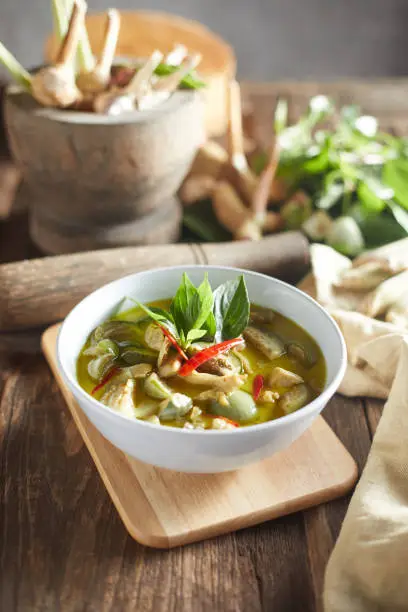 Photo of Thai food chicken green curry on wooden background.
