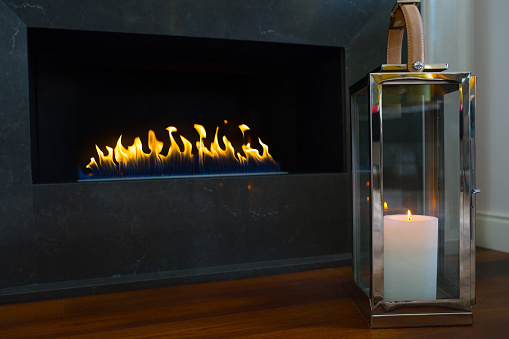 Fireplace and lit fire, interior in new luxury home