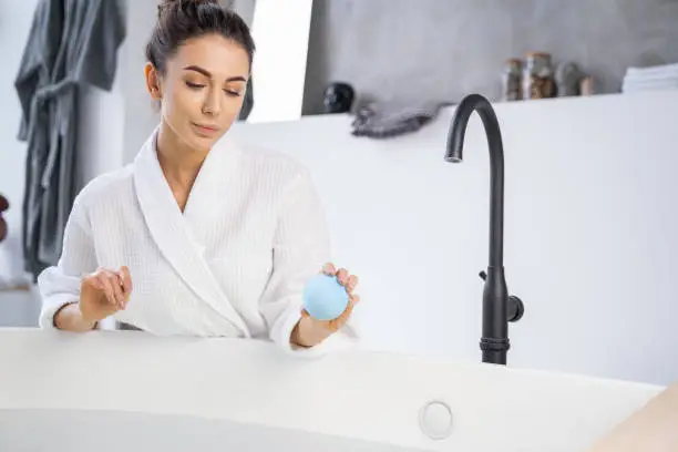 Pretty girl holding a bath bomb in her hand