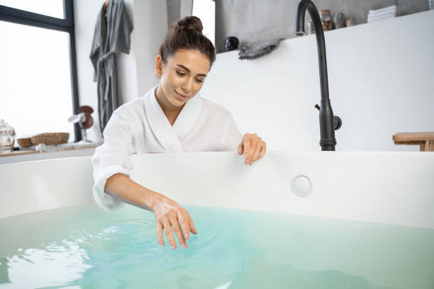 istock Smiling girl touching the surface of water 1195914421