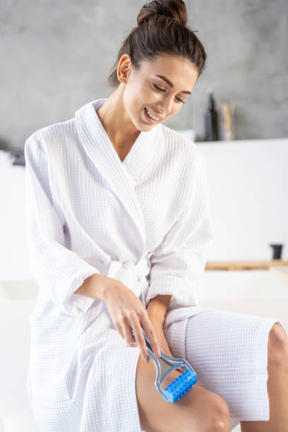 istock Girl in a bathrobe massaging her leg 1195914475
