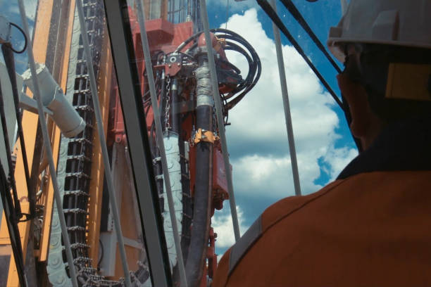 travailleur regarde par la fenêtre à la plate-forme pétrolière. plate-forme de forage. - crane mobile crane derrick crane construction vehicle photos et images de collection