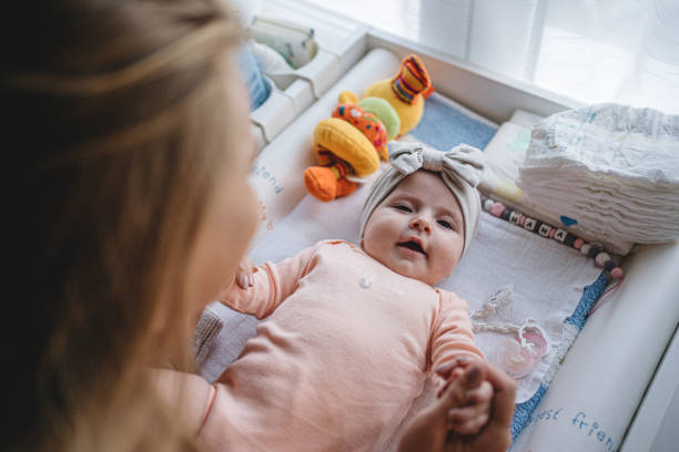 istock Cute serene baby on a changing mat in a home nursery 1195917337