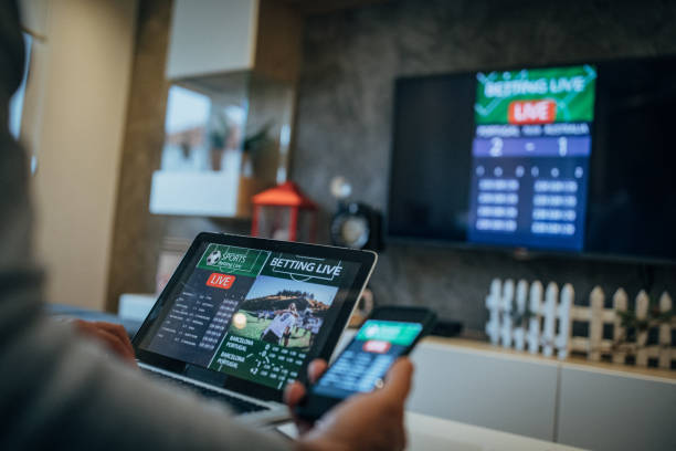 Man watches soccer game and bets in his living room One senior man watches soccer match and bets on the game. gambling stock pictures, royalty-free photos & images