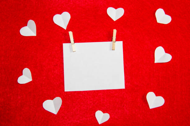 istock A red background from felt with white paper. Composition with hearts and place for writing a message. Background with place for write to valentines day or christmas. Clothespins hold a piece of paper 1195922663