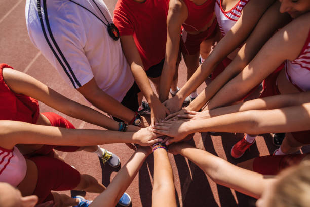 istock Motivated athletics team putting hands together 1195930707
