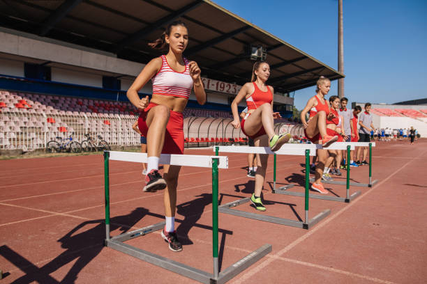 выделенная команда по легкой атлетике, осуществляющая спешку - hurdle hurdling track event women стоковые фото и изображения