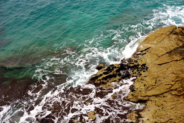 istock Deep sea with sea foam on the surface and waves that bumping on the rocky shore 1195934363