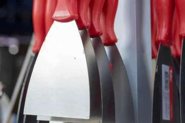 Multiple spatulas hanging on the counter. New unused. The photo was taken in front of the store.