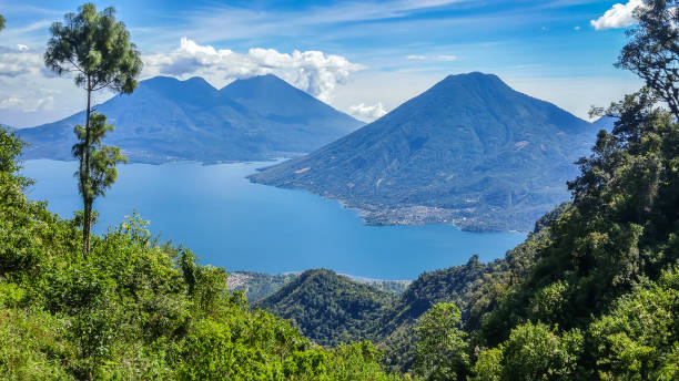 Lake Atitlán - Volcanoes - Guatemala - Central America San Marcos La Laguna area, Guatemala 11/25/2016: View of surrounding volcanoes with tranquil Lake Atitlán in foreground. guatemala landscape stock pictures, royalty-free photos & images