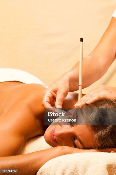 A Young Woman Getting Ear Candle Therapy Stock Photo - Download Image Now - Ear Candling, Candle, Adult