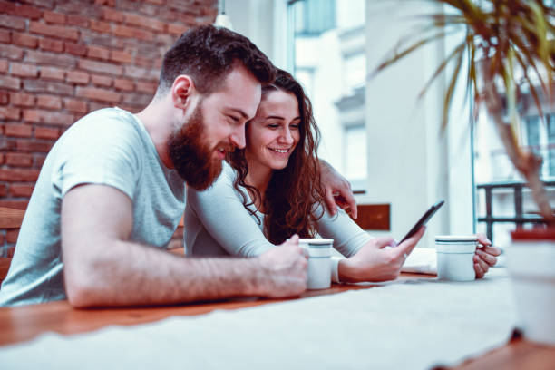istock Couple Drinking Coffee While Shopping Online On Smartphone 1195940419