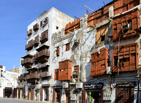 Jeddah, Mecca Region, Saudi Arabia: derelict remains of hedjazi architecture in Al Balad district, Abdul Hafidh Lane - buildings with shops and bent arabian closed balconies (rowshan - rawasheen / mashrabiyas), Historic Jeddah, the Gate to Makkah, UNESCO world heritage site. Red Sea coastal coral building tradition.