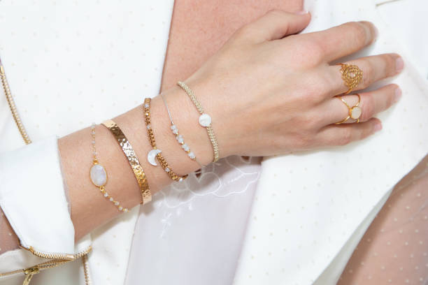 mujer cuello con mano con muchos brazaletes - female bracelet fotografías e imágenes de stock