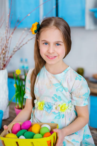 istock Cute girl holding basket with painted eggs. 1195942127