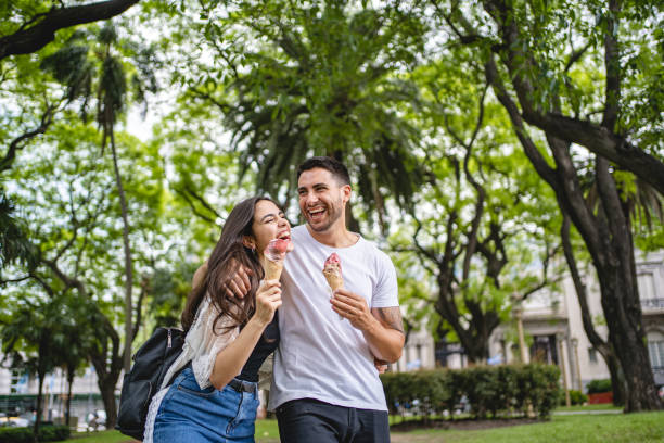 istock Couple eating sweet refreshments during a public park date 1195943862