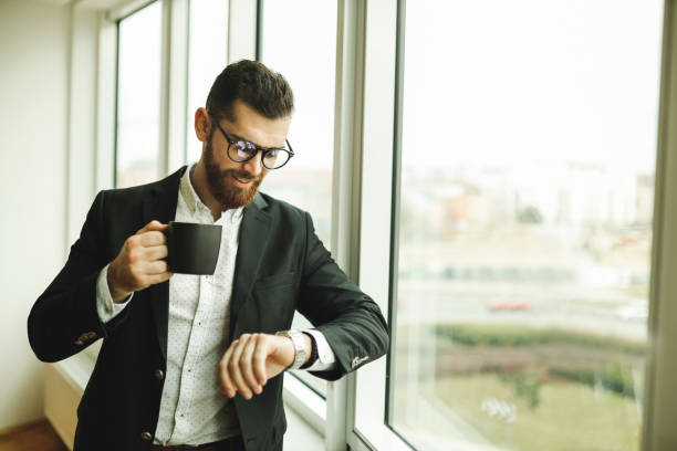 istock Businessman checking time and drinking coffee 1195946628