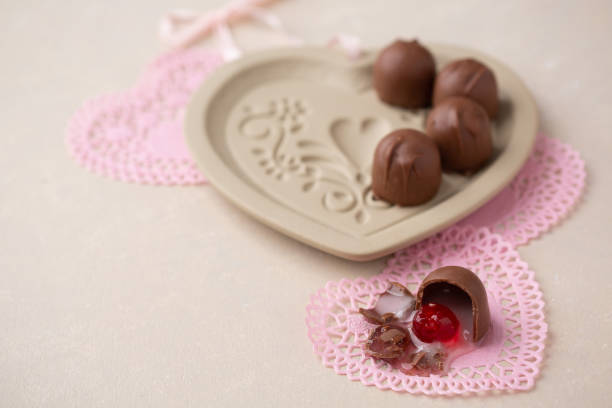 istock Chocolate Covered Cherries Displayed in Heart-Shaped Dish with Pink Heart-Shaped Doilies. 1195949328