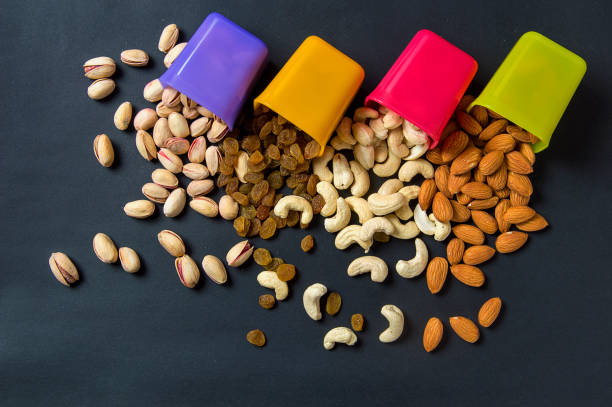 istock Healthy Mix Dry Fruits and Nuts on dark background. Almonds, Pistachio, Cashews, Raisins 1195957504